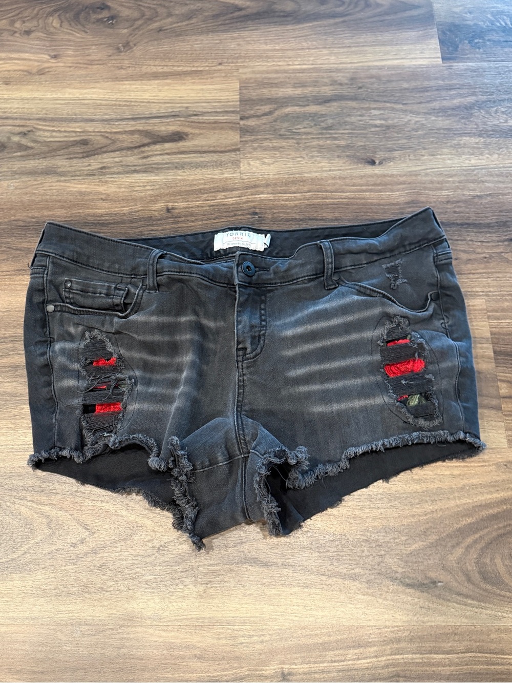 torrid Women’s size 18 Black Distressed Denim Cutoff Shorts with Red Underlay.